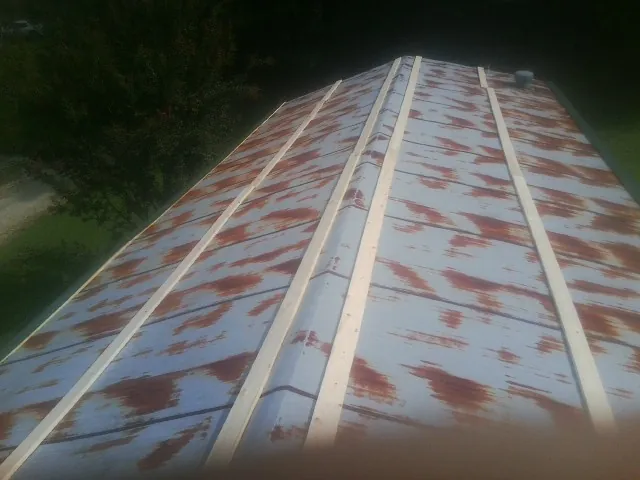 Rusted metal roof panels with new wood purlins before replacement — Storm Damage Roof Repair in Horace by Roofing Brothers
