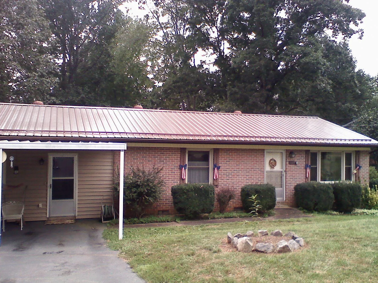 Bronze metal roof and carport on a brick ranch home — Roof Repair work by our crew in Horace